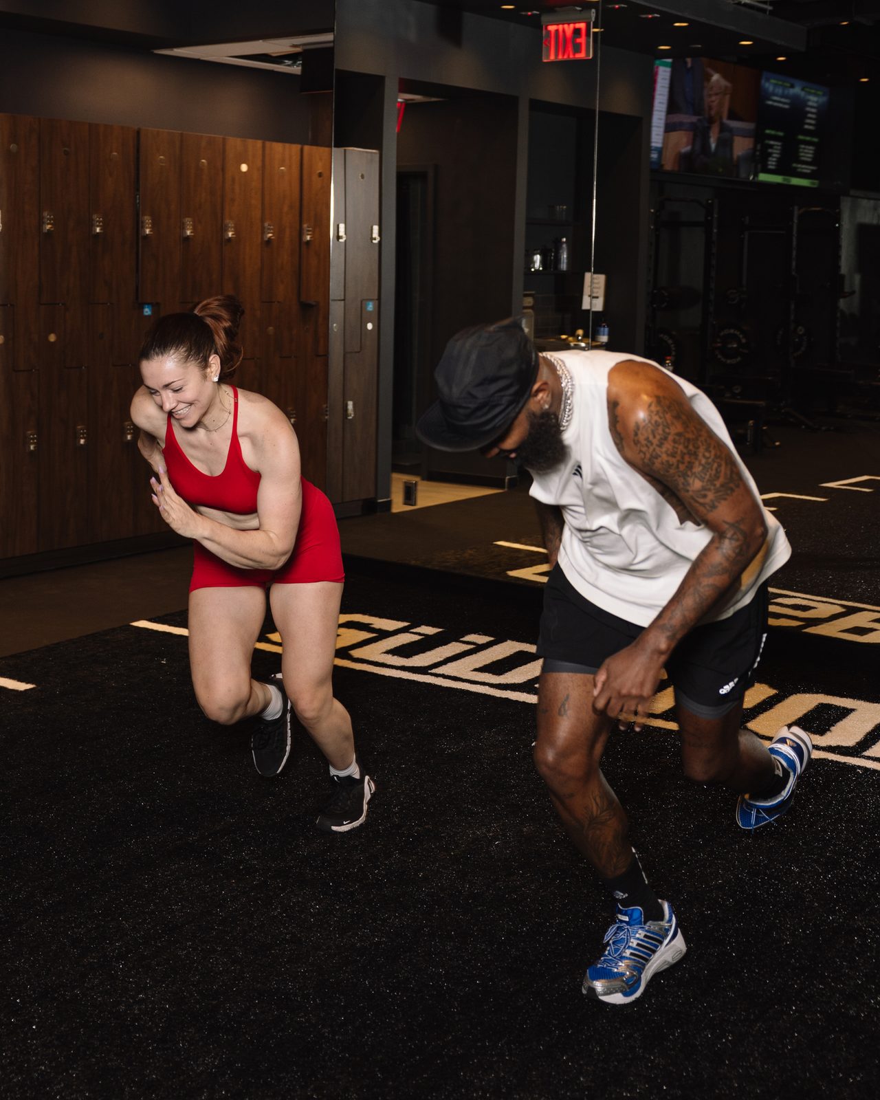 Two athletes sprinting through a conditioning set on the GÜDSPORT floor inside The Oculus at WTC