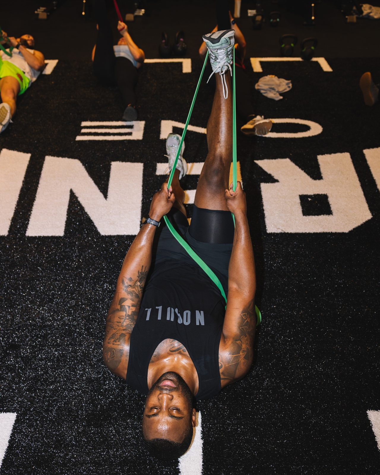 Athlete stretching with a resistance band on the GÜDSPORT floor inside The Oculus at WTC